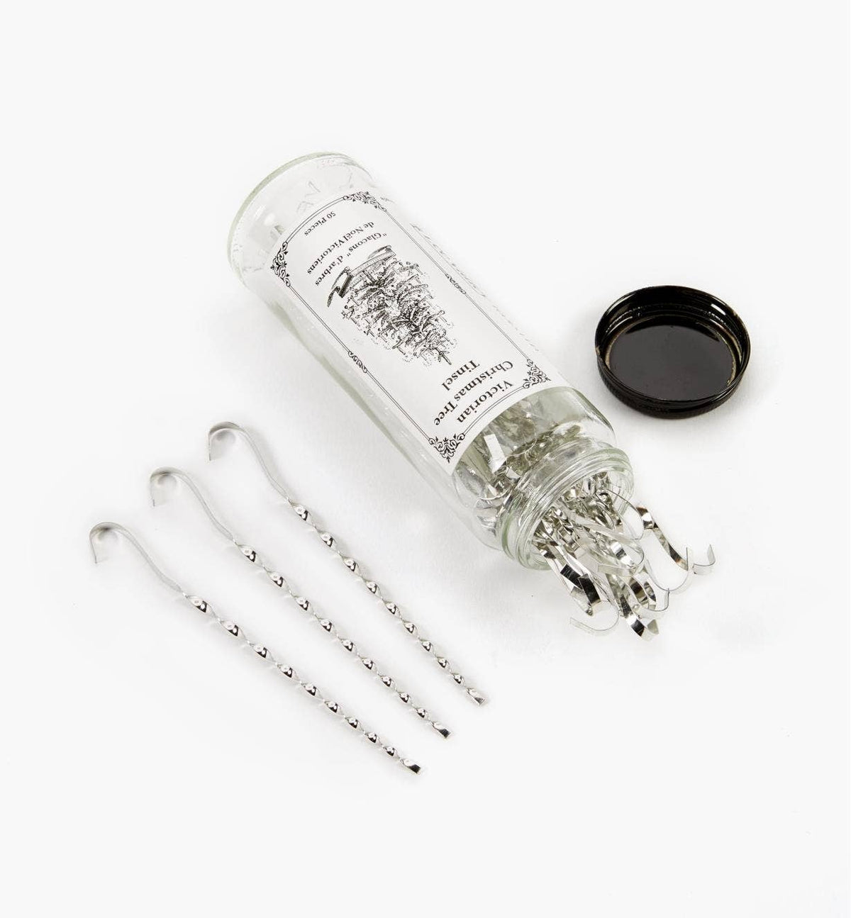 Reusable Victorian tin Christmas tinsel displayed beside glass storage bottle