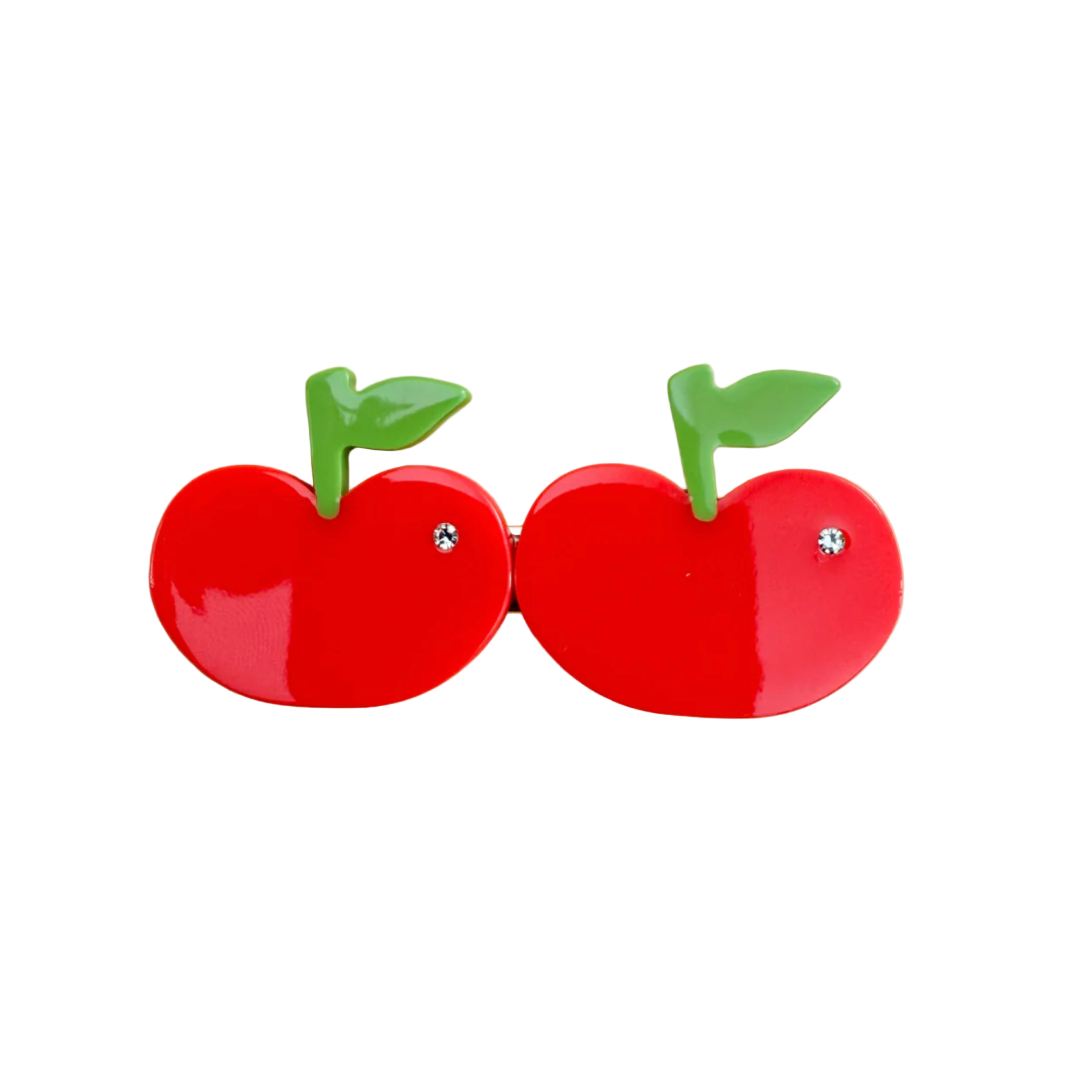 The Cherry Hair Clip features glossy red cherries, green stems and sparkling crystal details, crafted from colorful cellulose acetate.