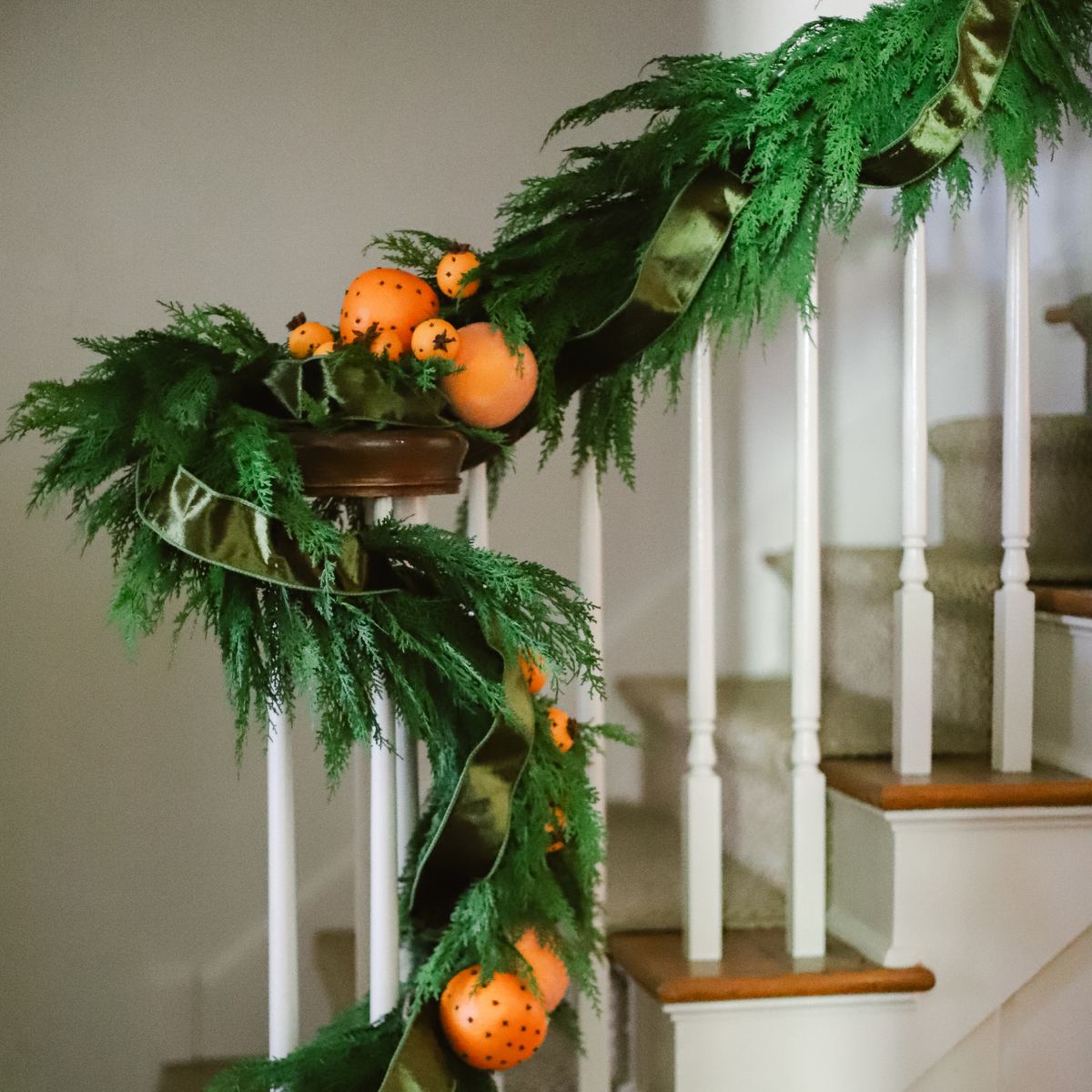 Hampshire Cedar Garland styled on staircase with green velvet ribbon and oranges