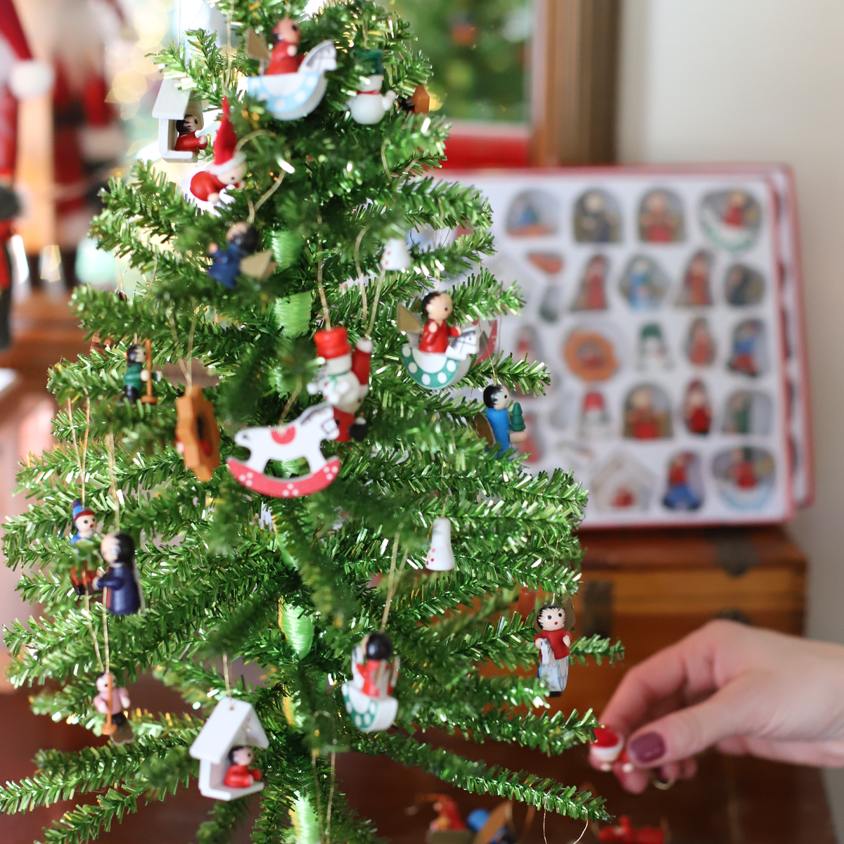 Close-up of 18 inch green mini Christmas tree decorated with miniature Santas angels rocking horses and snowmen