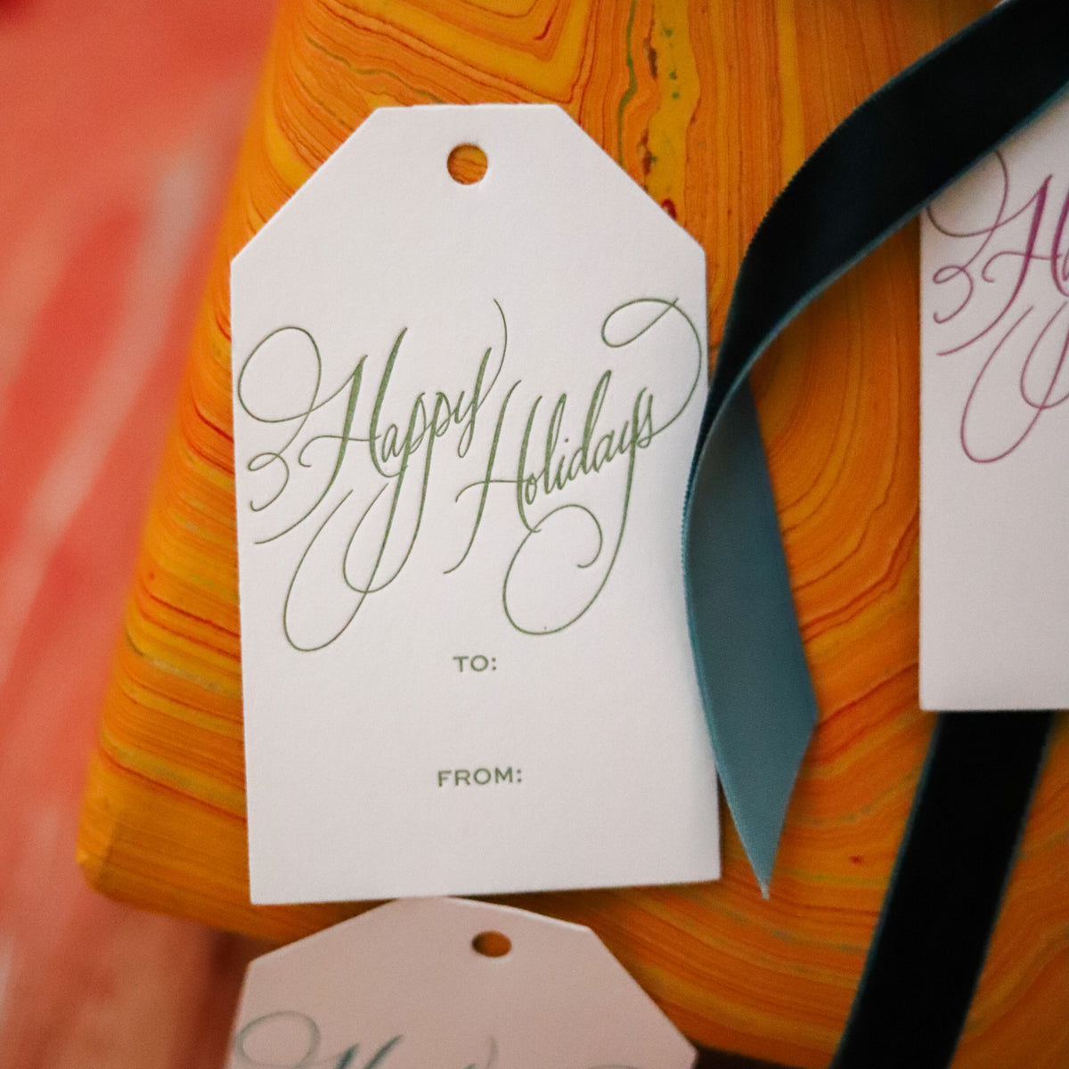 Shop Happy Holidays Gift Tags in sets of 8, featuring elegant hand-lettered lettering, To and From lines, and coordinating color options for festive gift wrapping.