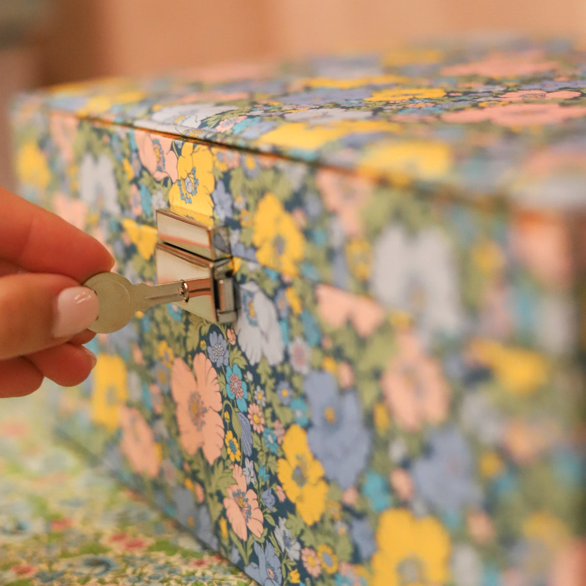 Top your dressing table with this beautiful and practical jewelry box. Fitted with a lock and key and covered in Liberty of London fabric, this jewelry box has an organizational tray that lifts out to reveal additional divided storage. 