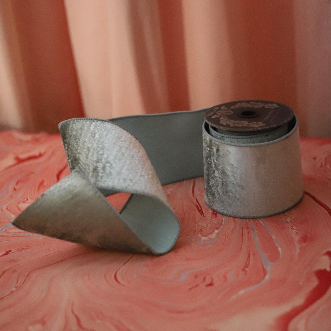 4" Wide Celadon Velvet wired ribbon shown on a marbled red backdrop