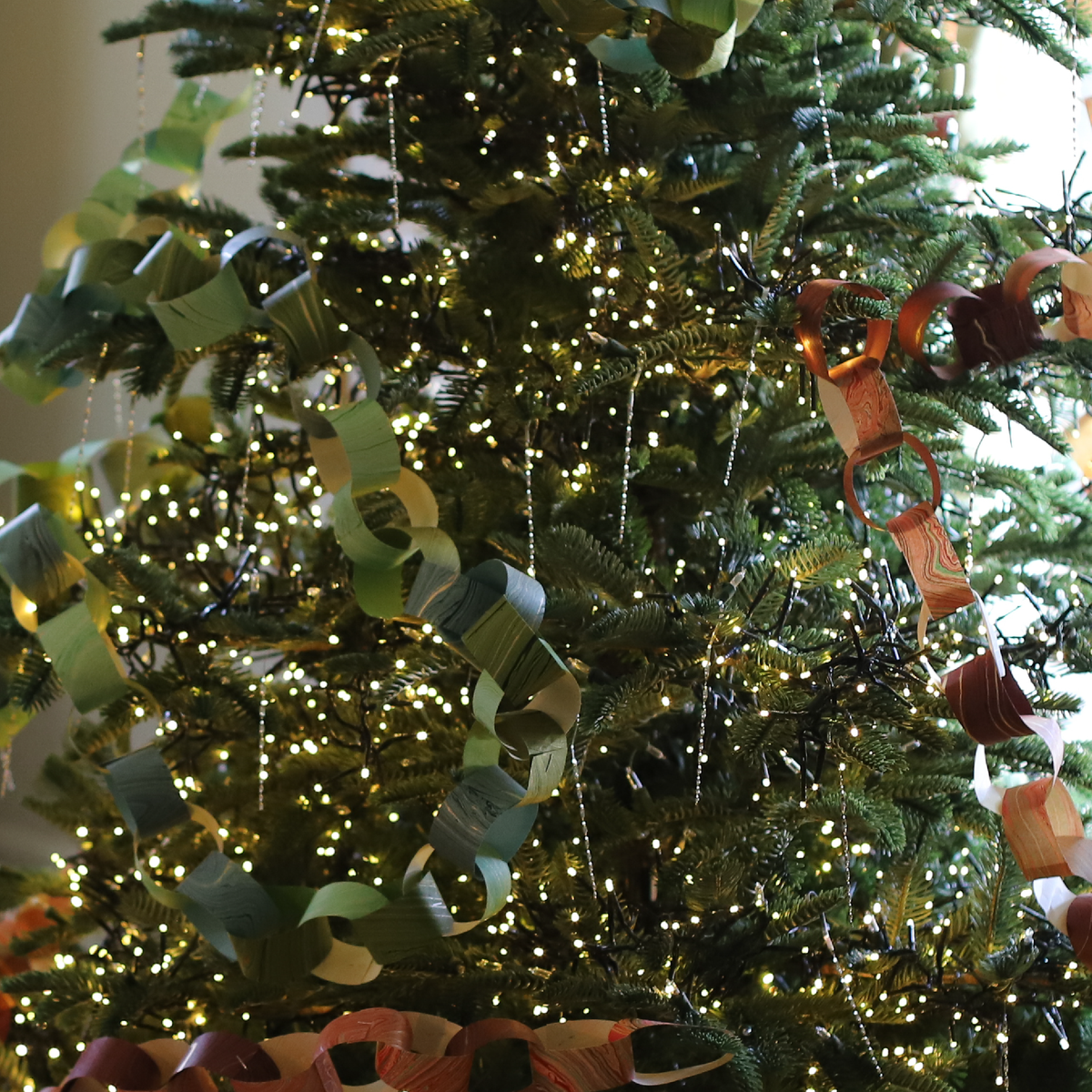Victorian Christmas Tree Tinsel hanging from a Christmas tree with paper chain garland and warm white lights