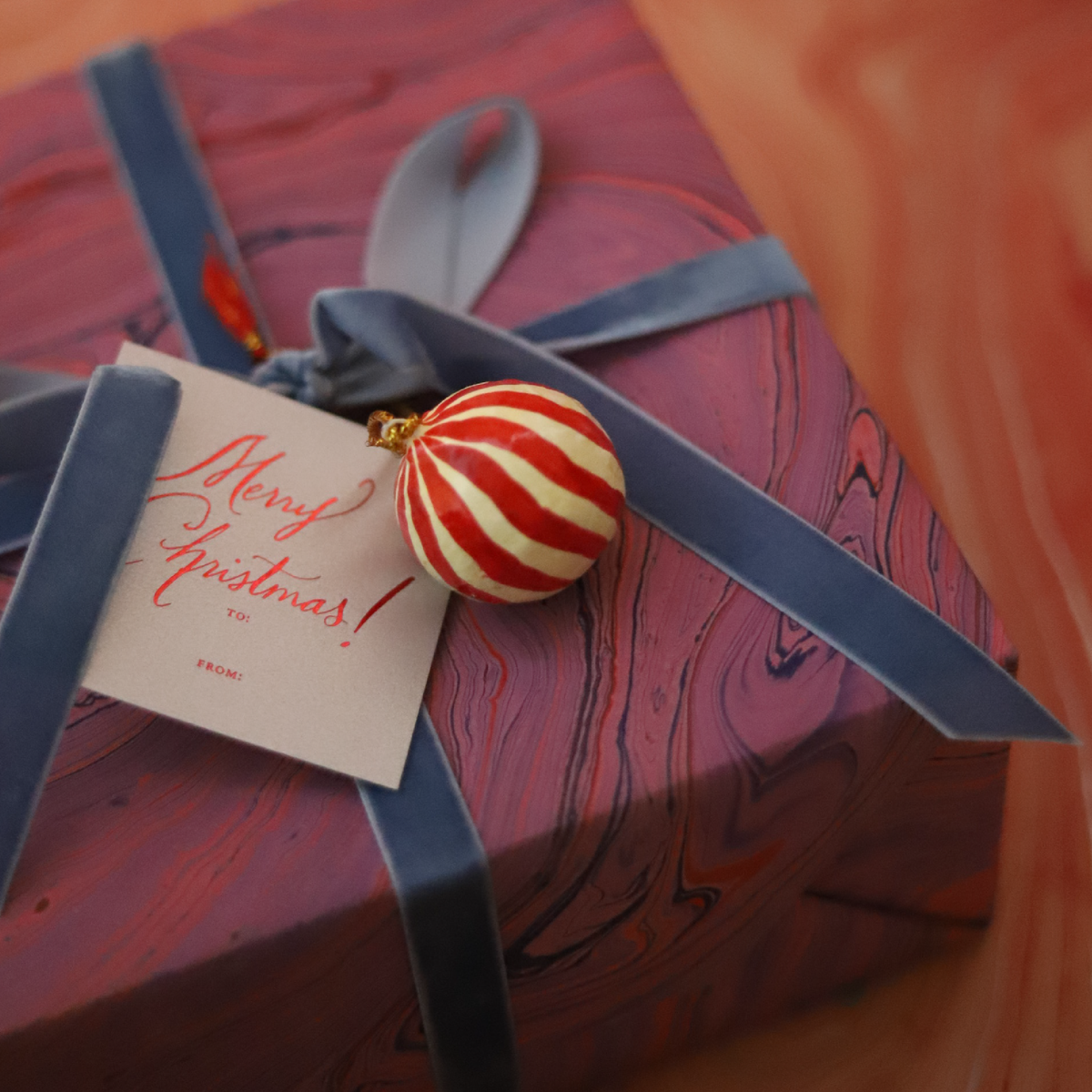 miniature hand-painted paper mache baubles used as gift wrap embellishments on a yellow wrapped present