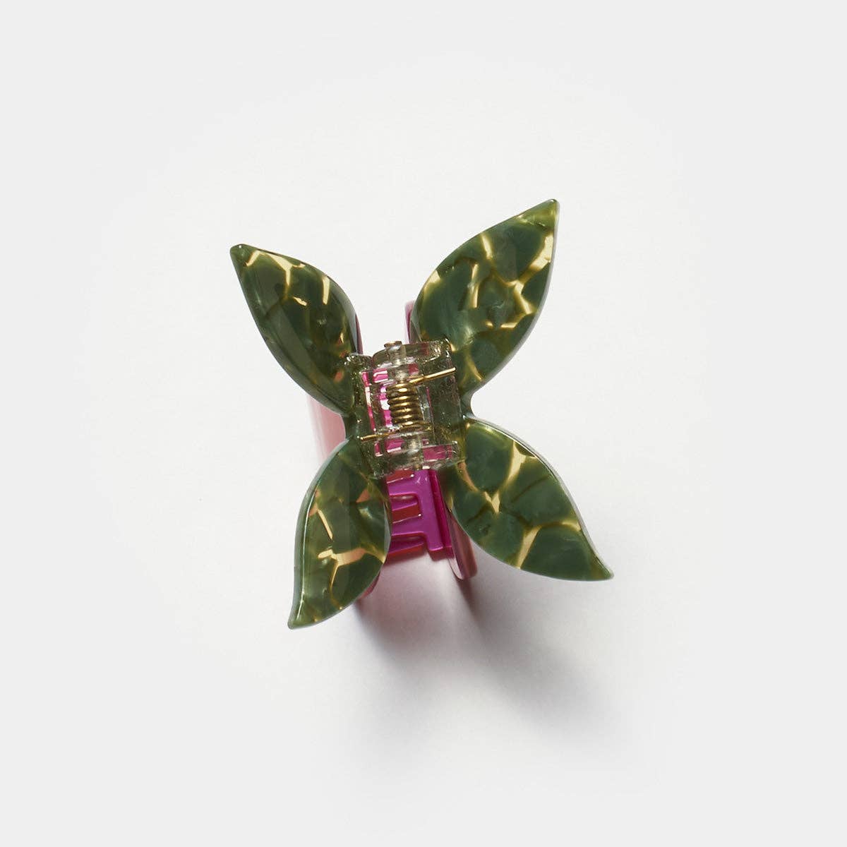 The Pomegranate Hair Claw features a glossy red fruit with deep green leaves and a whimsical butterfly-style handle for a playful botanical touch.