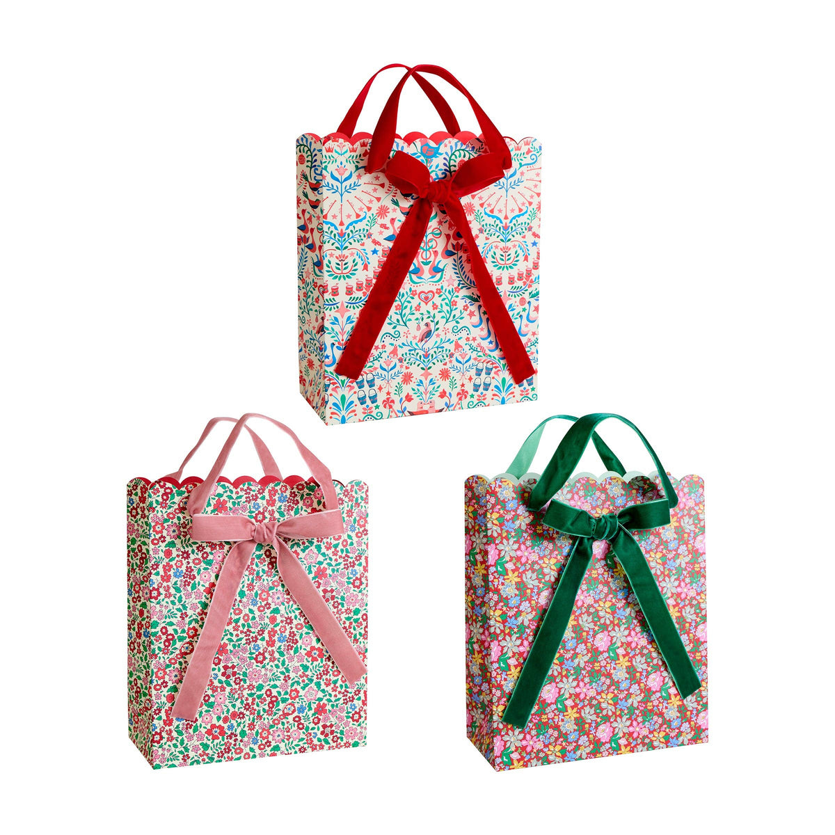 Three floral gift bags with colorful ribbons on a white background