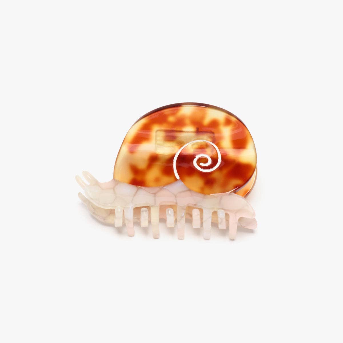 The Sea Snail Hair Claw features a pearlescent body and amber tortoise shell, crafted from individually cut cellulose acetate for a playful statement.