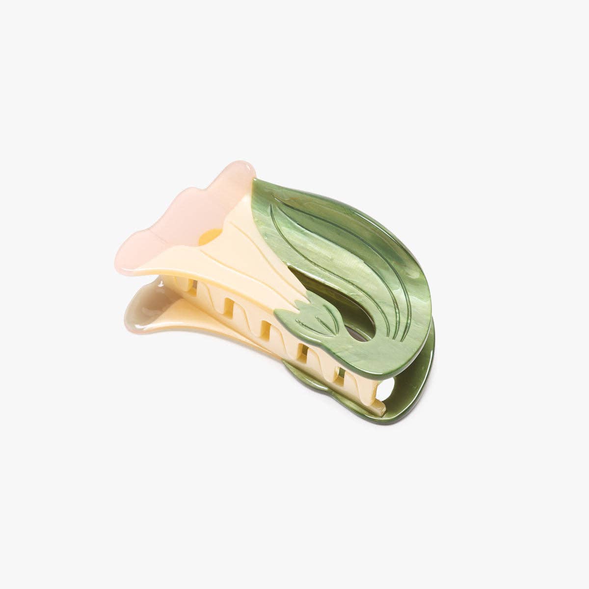 The White Iris Hair Clip features soft ivory petals and layered green leaves, handcrafted from cellulose acetate for an elegant botanical statement.