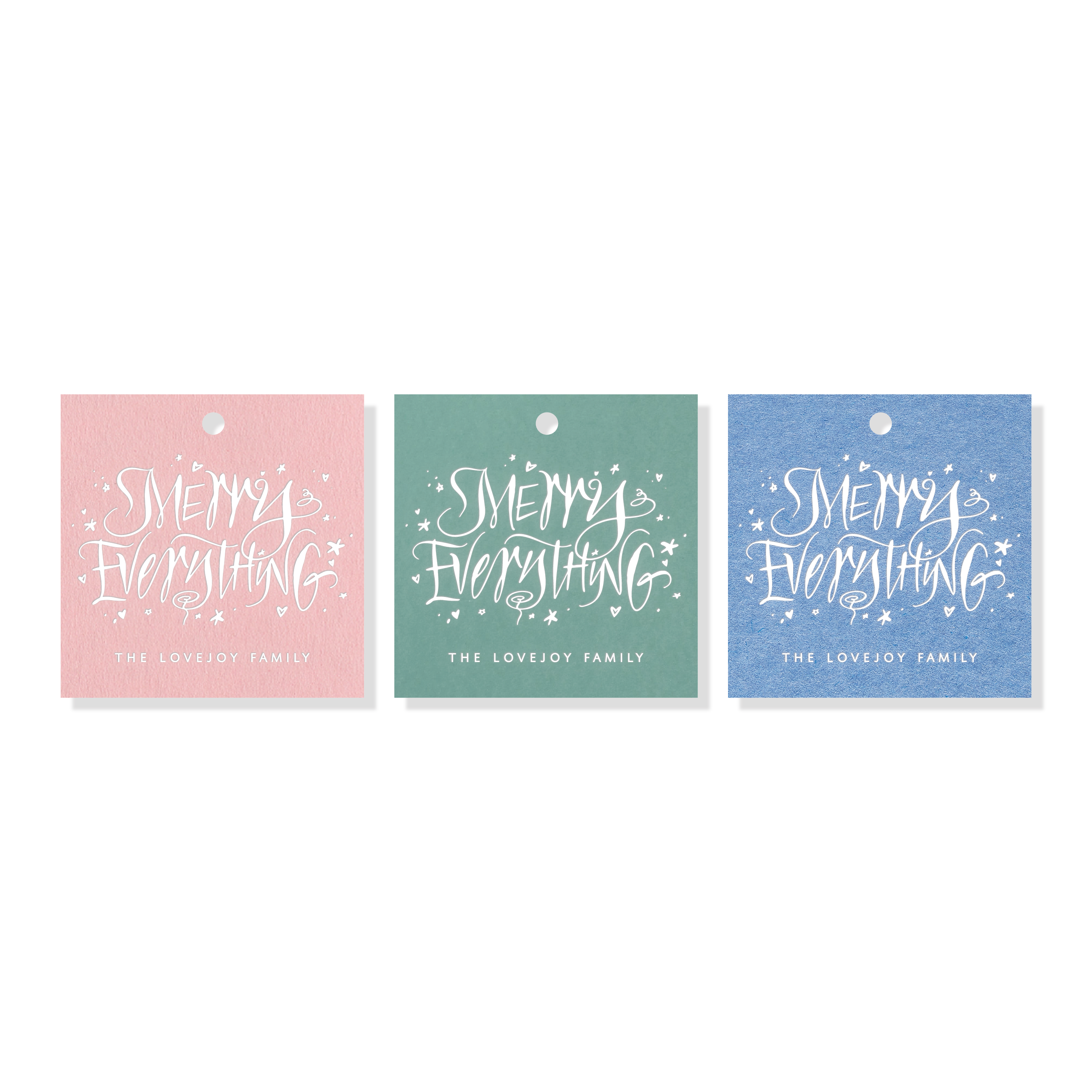 Engraved “Merry Everything” gift tags shown in pink, green, and blue paper with white calligraphy and personalized family name text.