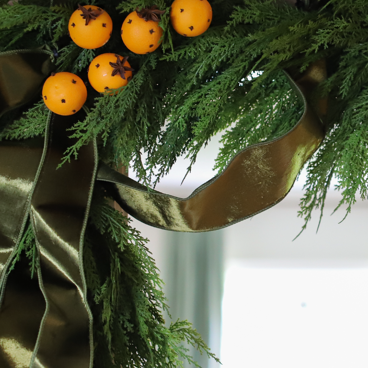 Close-up of real-touch Hampshire Cedar Garland with velvet ribbon and citrus