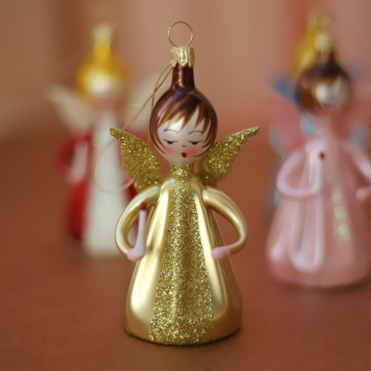 Gilded Little Angel Italian glass Christmas ornament by Soffieria De Carlini with gold gown, glitter wings, and candle