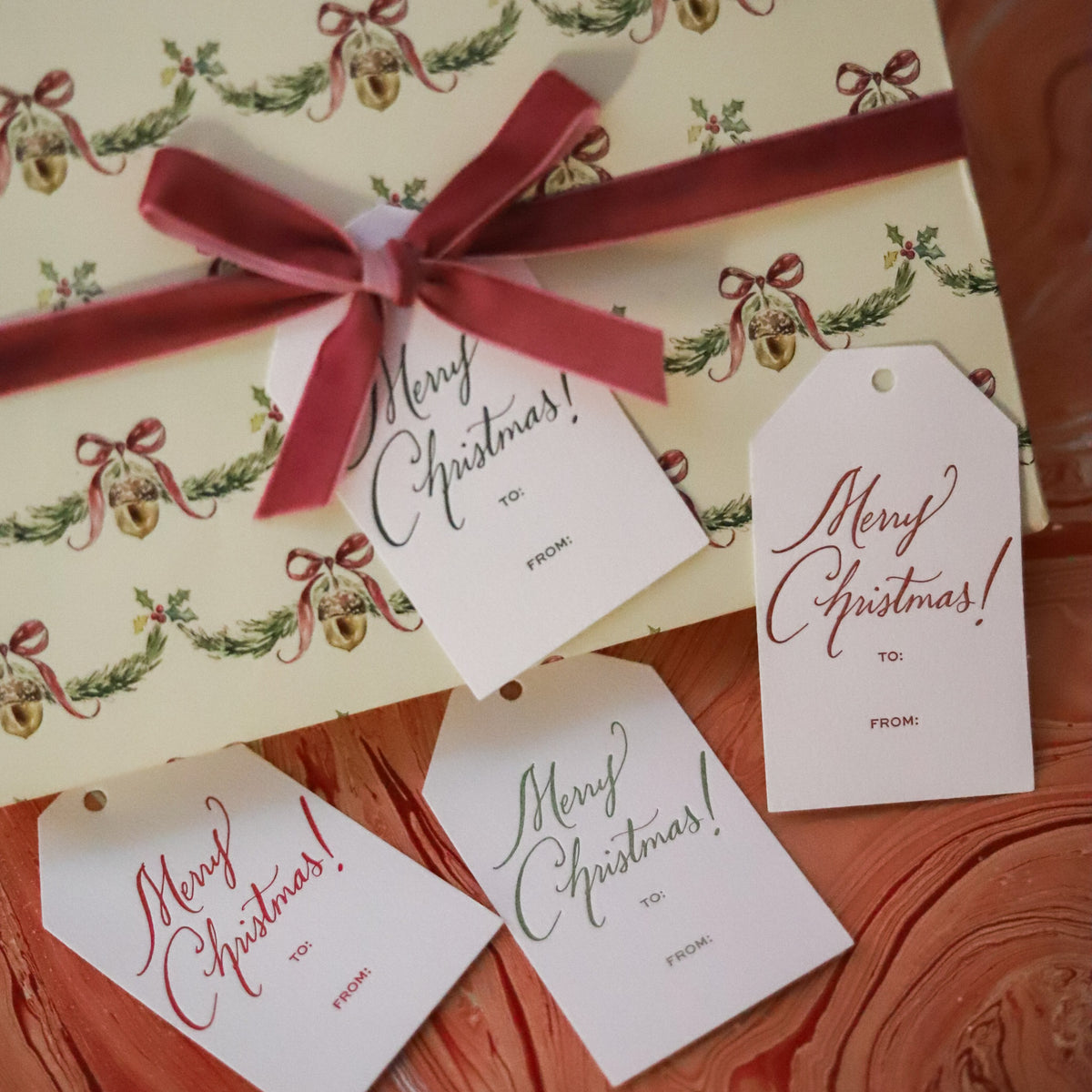 Shop Merry Christmas Gift Tags in sets of 8, featuring elegant hand-lettered lettering, To and From lines, and coordinating color options for holiday wrapping.