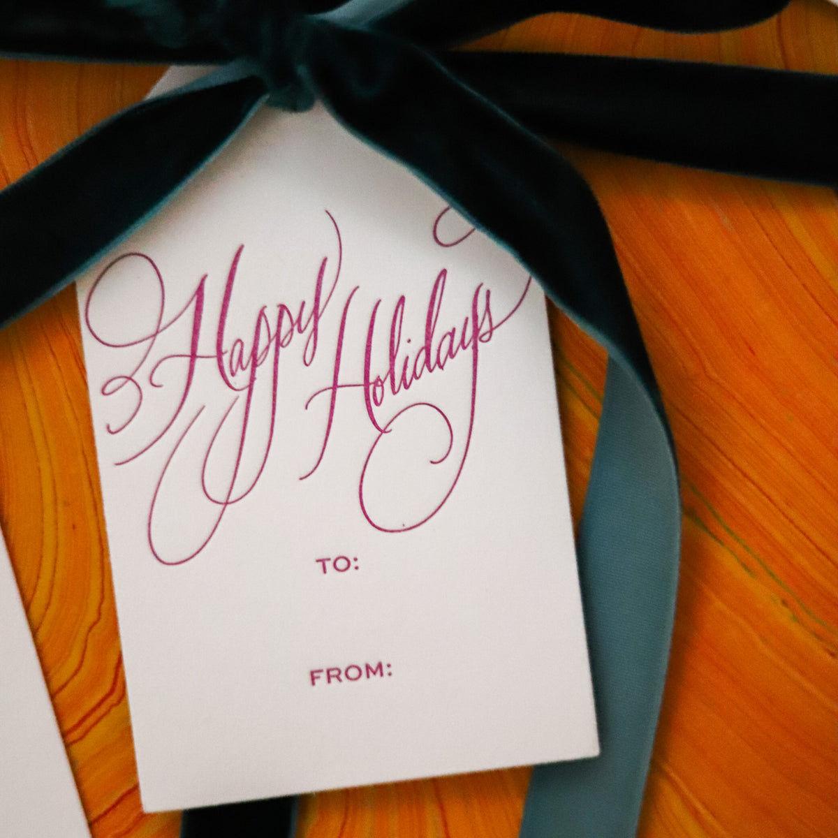 Shop Happy Holidays Gift Tags in sets of 8, featuring elegant hand-lettered lettering, To and From lines, and coordinating color options for festive gift wrapping.