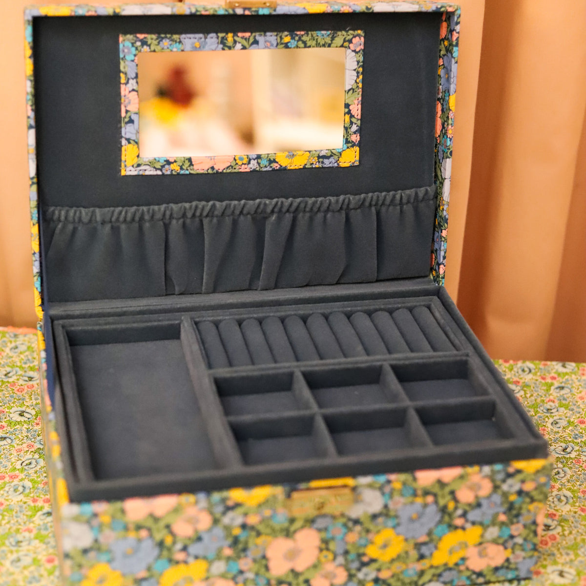 Top your dressing table with this beautiful and practical jewelry box. Fitted with a lock and key and covered in Liberty of London fabric, this jewelry box has an organizational tray that lifts out to reveal additional divided storage.&nbsp;&nbsp;