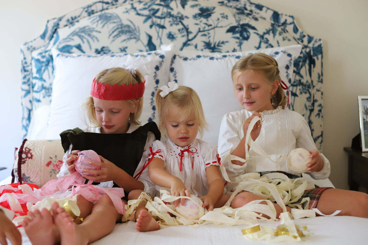 Children unwinding crepe paper Holiday Surprise Balls filled with tiny Christmas treasures