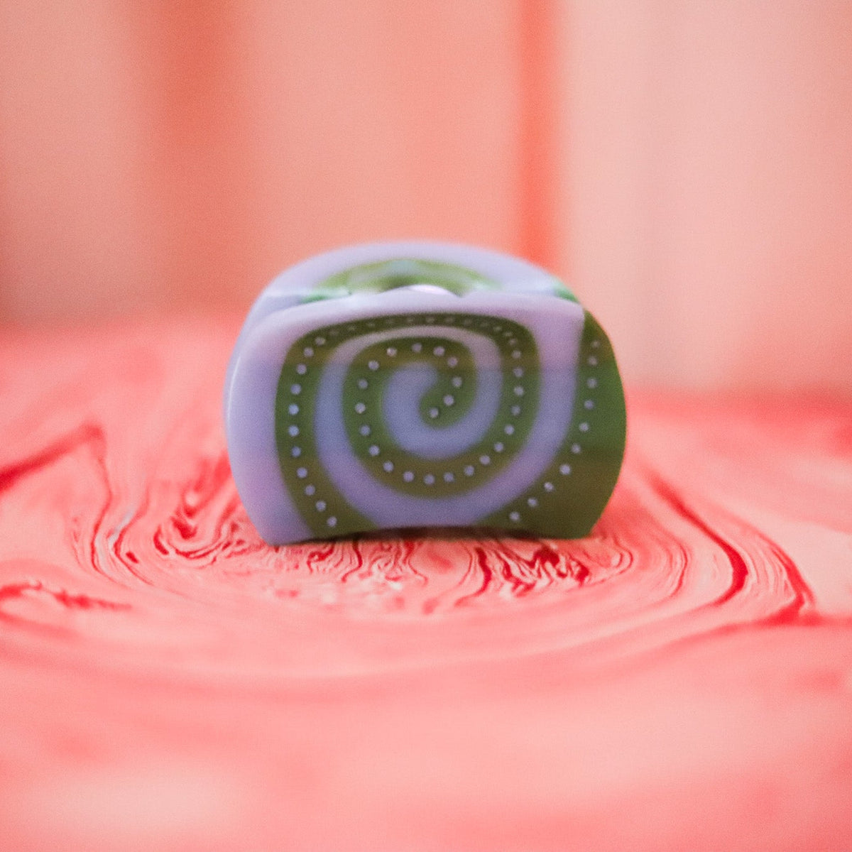 The Laguna Spiral Hair Claw features soft blue and green cellulose acetate with sparkling rhinestone details in a sculptural swirl design.
