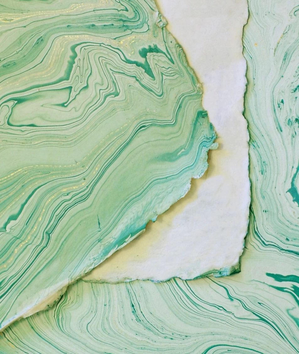 Abstract marbled art print featuring flowing green, mint, and teal swirls with a central diagonal white border, presented as a flat-lay texture design.